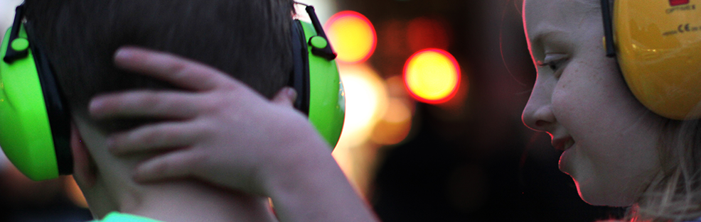 Mainstreaming OSH into education. Two kids wearing ear protection headsets